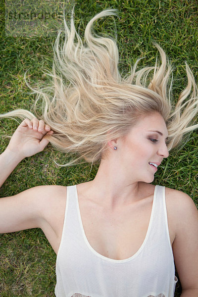 Frau im Gras liegend