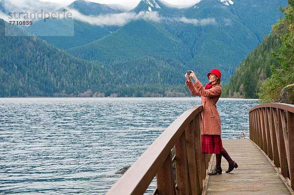 Frau fotografiert auf Holzbrücke