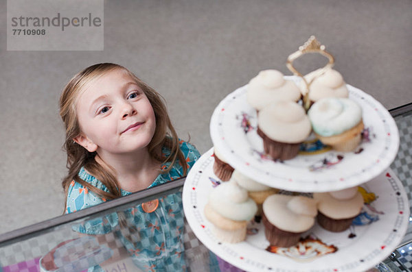 Mädchen bewundern Muffins in der Bäckerei