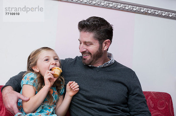Vater und Tochter essen Muffins