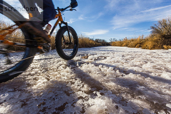 Mountainbiker auf Schnee im ländlichen Raum