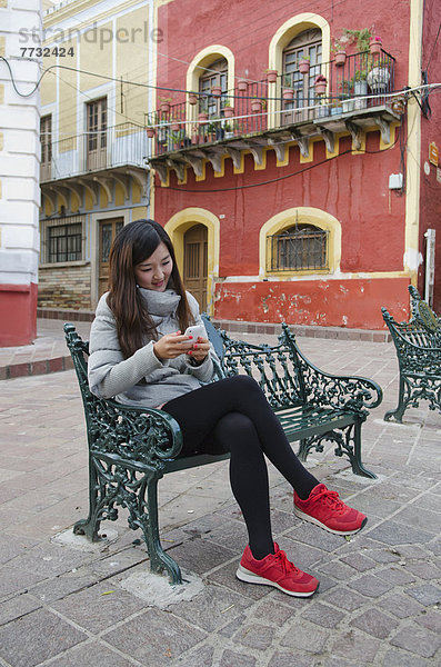 Handy  sitzend  Frau  sehen  Stadt  Sitzbank  Bank  Mexiko  jung  südkoreanisch  Guanajuato  alt  spanisch