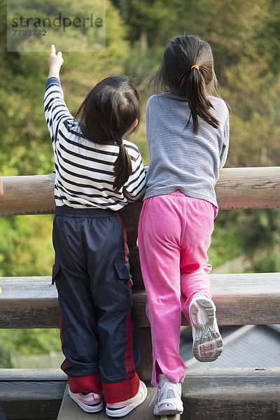 hoch oben stehend Zusammenhalt zeigen Geländer Zaun 2 jung Mädchen Japan Kyoto