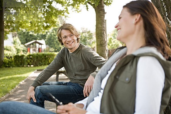 Eine junge Frau und ein junger Mann flirten im Park