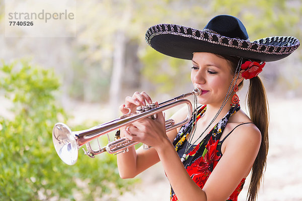 USA  Texas  Young woman playing trumpet