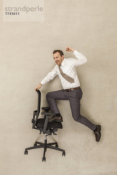 Geschäftsmann Schlittschuhlaufen auf Bürostuhl