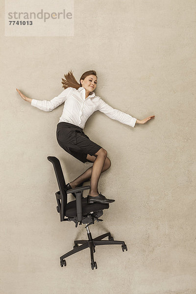 Geschäftsfrau Schlittschuhlaufen auf Bürostuhl