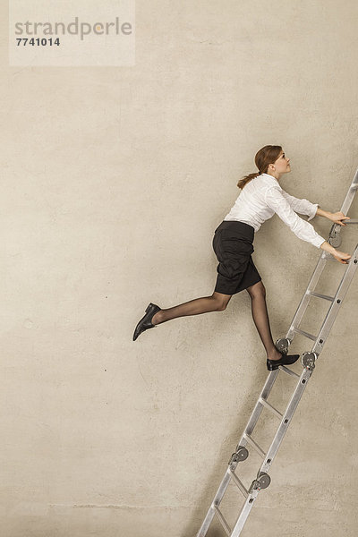 Geschäftsfrau klettert Leiter im Büro