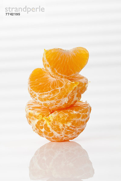 Stapel geschälter frischer Clementinen auf weißem Hintergrund  Nahaufnahme