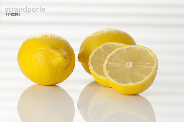 Ganze und halbierte frische Zitronen  Nahaufnahme