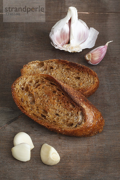 Gebratenes Brot mit Knoblauch auf Holztisch  Nahaufnahme