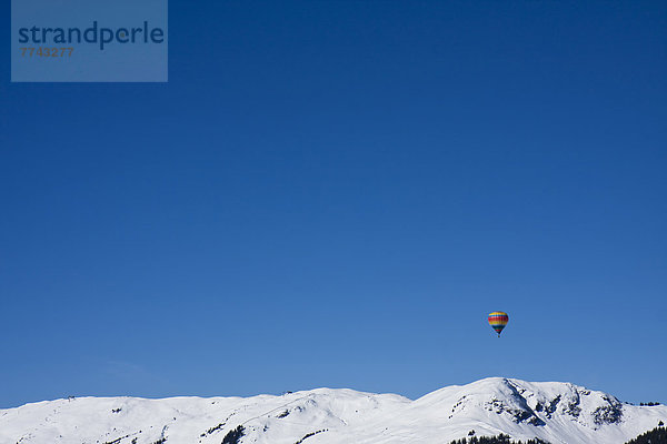 Österreich  Heißluftballon über den Bergen in Saalbach