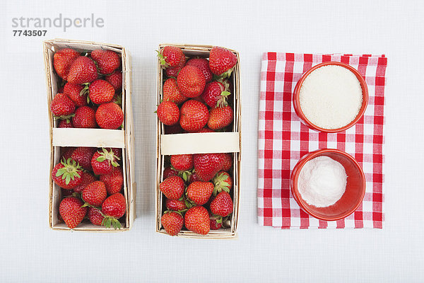 Rohrzucker und Pektin für Erdbeermarmelade mit frischen Erdbeeren im Holzkorb