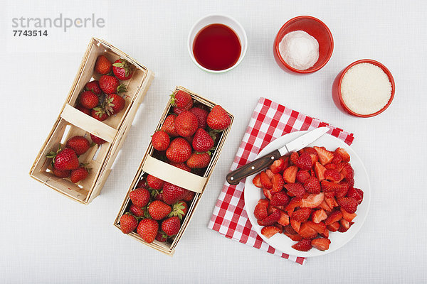 Rohrzucker und Pektin für Erdbeermarmelade mit frischen Erdbeeren im Holzkorb