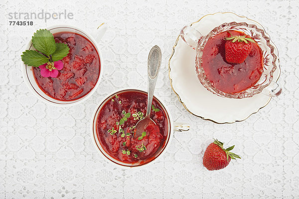 Schale mit frischer hausgemachter Erdbeermarmelade auf Teller