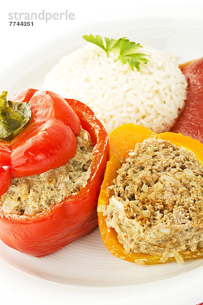 Teller gefüllter Paprika mit Reis und Tomatensauce auf weißem Grund  Nahaufnahme
