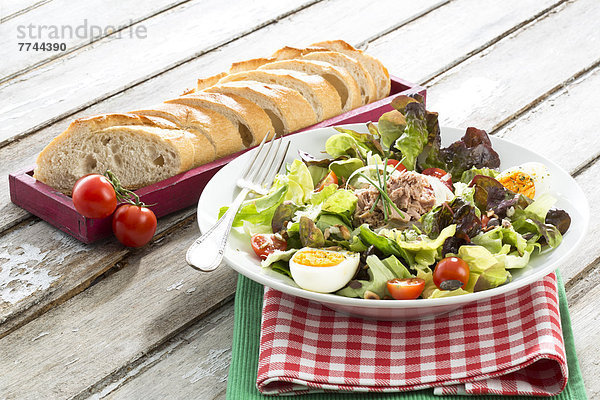 Salatteller mit Thunfisch und Brot im Tablett auf dem Tisch  Nahaufnahme