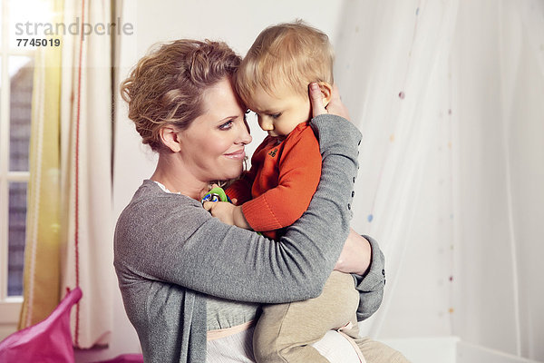 Deutschland  Bonn  Schwangere Mutter mit Sohn  lächelnd