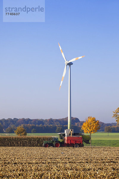 Deutschland  Nordrhein-Westfalen  Blick auf Windkraftanlage mit Erntefahrzeug bei Coesfeld