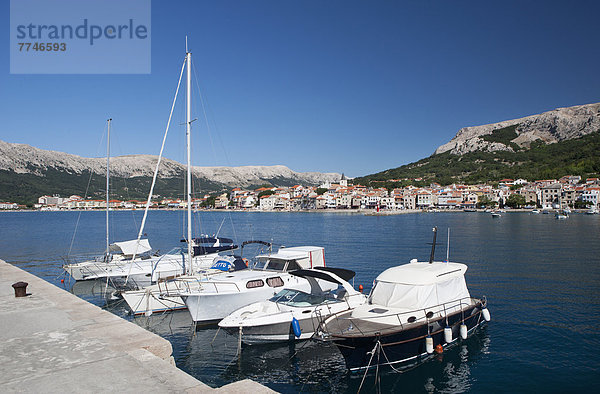Kroatien  Boot liegt im Hafen auf der Insel Krk mit der Stadt Baska im Hintergrund.
