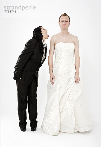 Braut in Anzug zeigt Bräutigam in Hochzeitskleid die Zunge  Kleidertausch  Hochzeit