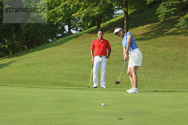Frau  jung  einlochen  Ball Spielzeug  Golfsport  Golf