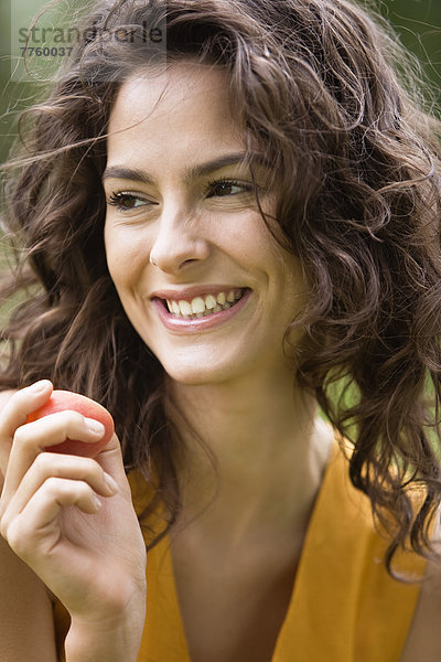 Porträt einer jungen Frau mit einer Aprikose
