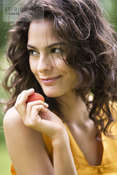 Porträt einer jungen Frau mit einer Aprikose