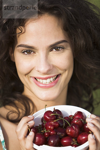 Porträt einer jungen Frau mit einer Schale voller Kirschen