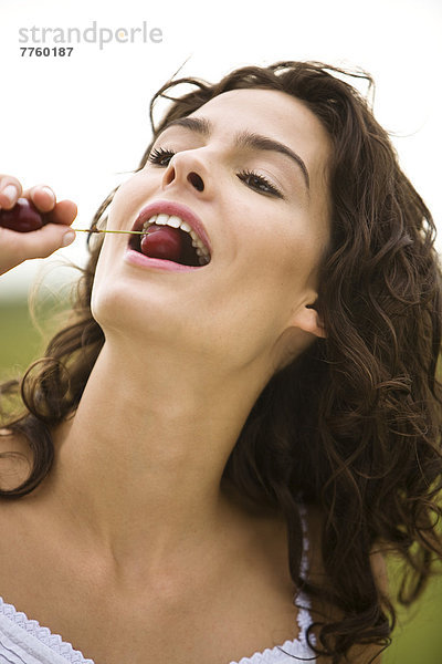 Junge Frau isst eine Kirsche  oudoors