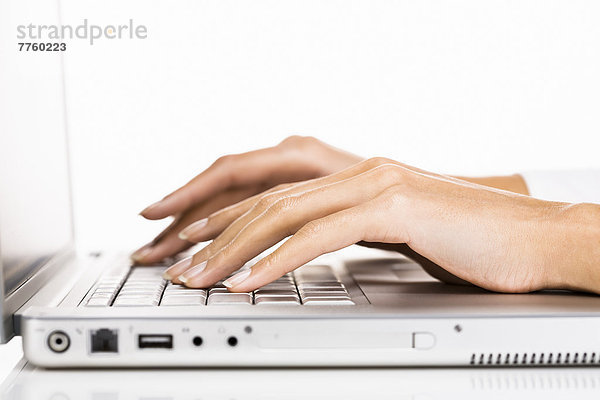 Frauenhände schreiben auf Laptop