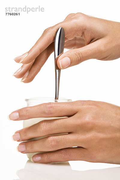 Frauenhände mit Löffel und Joghurt
