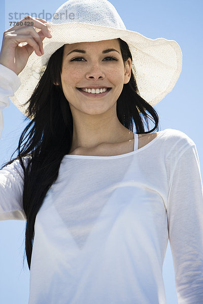 Porträt einer jungen lächelnden Frau  weißer Hut