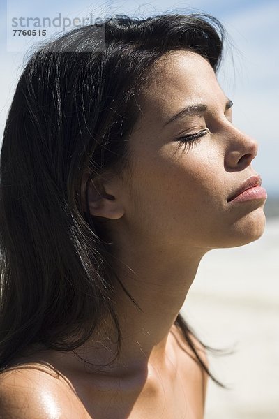 Braunhaarige junge Frau am Strand  Sommer