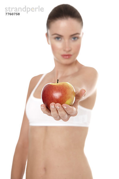 Frau in Unterwäsche hält Apfel