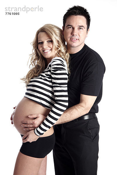 Mann mit Händen auf dem Bauch einer schwangeren Frau