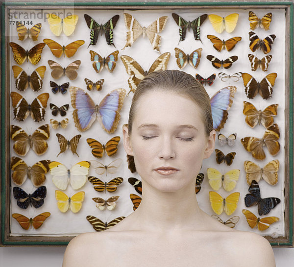 Porträt der jungen Frau durch Schmetterlingssammlung