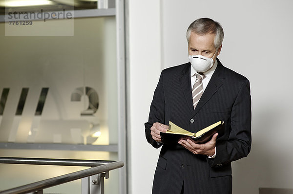 Geschäftsmann mit Schweinegrippe-Maske
