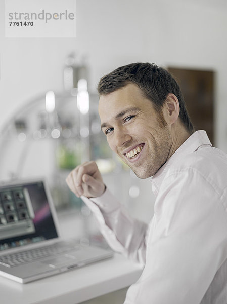 Lächelnder Mann mit Laptop-Computer