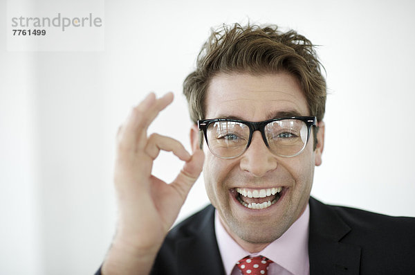 Porträt eines lächelnden Geschäftsmannes mit OK-Geste
