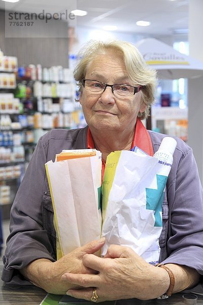 Frankreich  Apotheke  Seniorin mit vielen Medikamenten
