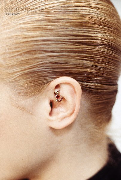 Nahaufnahme der Frau im Profil  Piercing im Ohr