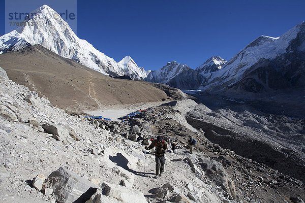 Wanderweg im Everest-Nationalpark  hinten die Ortschaft Gorak Shep und die Berge Kalar Patthar und Pumori  links  sowie der Khumbu-Gletscher  rechts