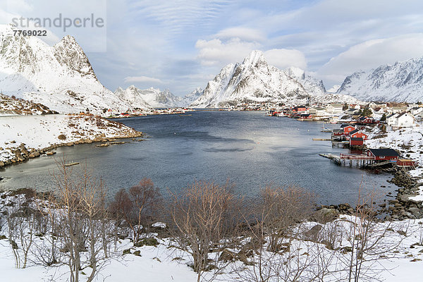 Fischerort mit roten Hütten am Fjord im Winter