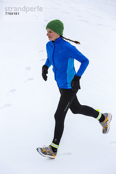 Joggerin bei einem winterlichen Lauf im Schnee
