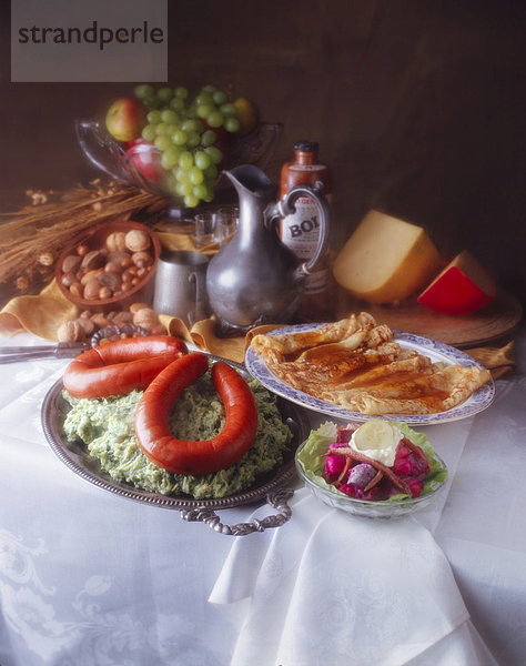 Stillleben mit Speisen im Stil eines holländischen Gemäldes  mit Würstchen  Pfannkuchen  Obst und Käse