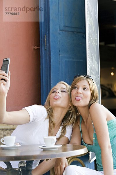 Zwei junge Frauen beim Selbstporträt mit Handy  draußen
