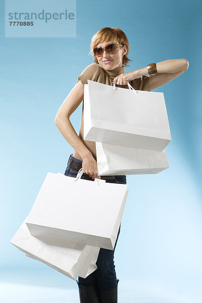 Portrait von Claire mit Einkaufstasche auf hellblauem Hintergrund