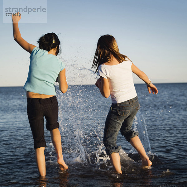 Zwei kleine Mädchen spielen in einem See