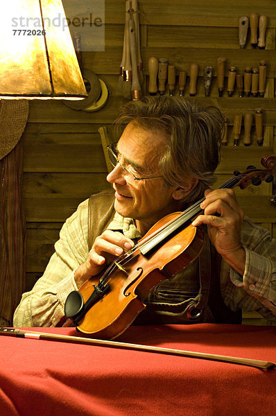 Mann beim Stimmen einer Geige